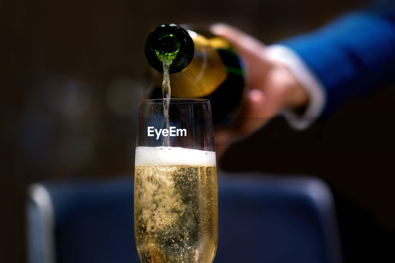 Cropped image of waiter pouring champagne in flute