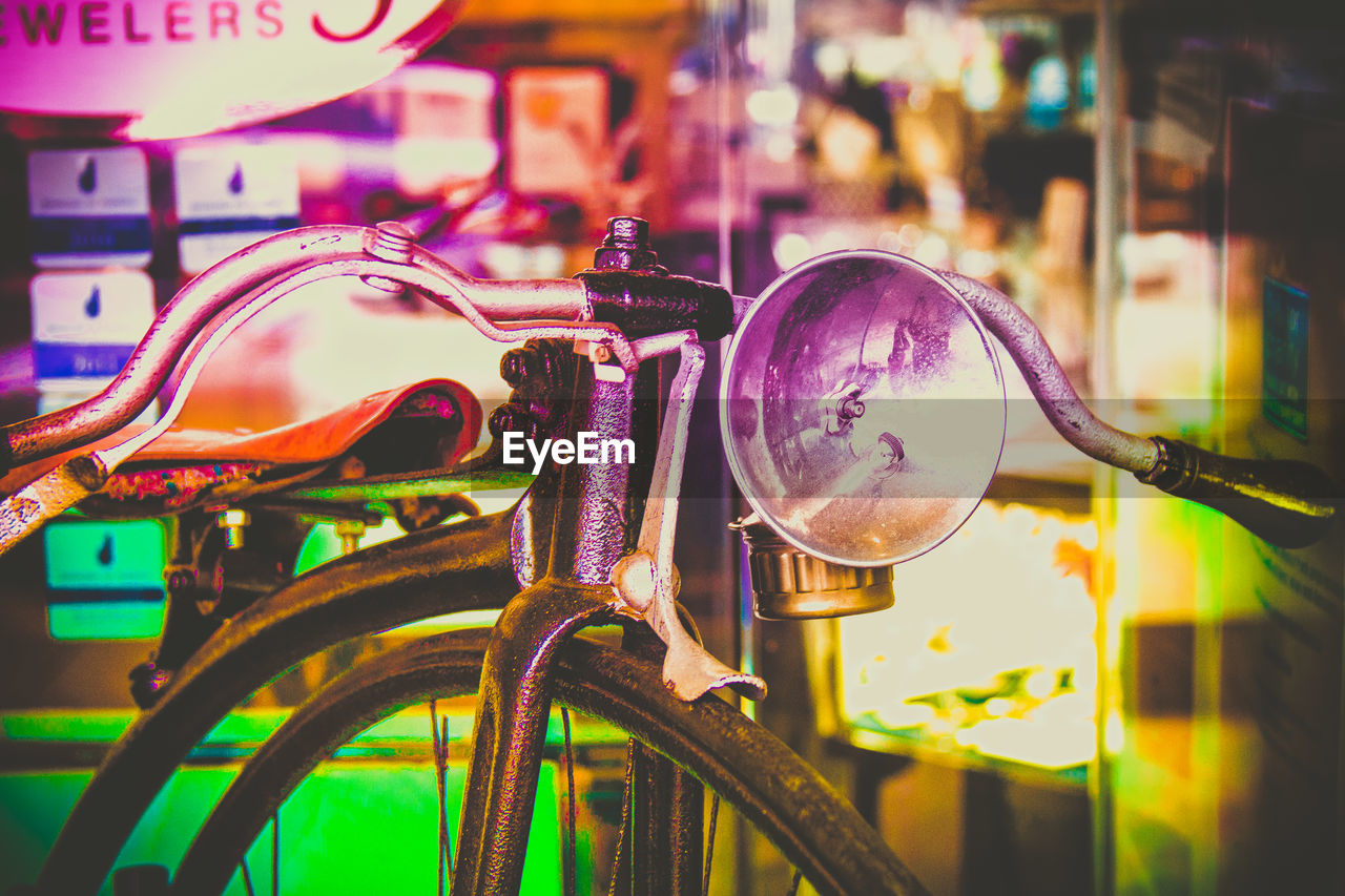 CLOSE-UP OF MULTI COLORED BICYCLE HANGING ON METAL