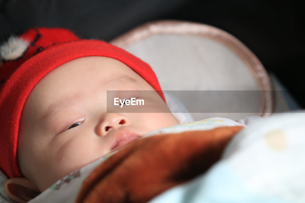 Close-up of cute baby boy sleeping on bed at home