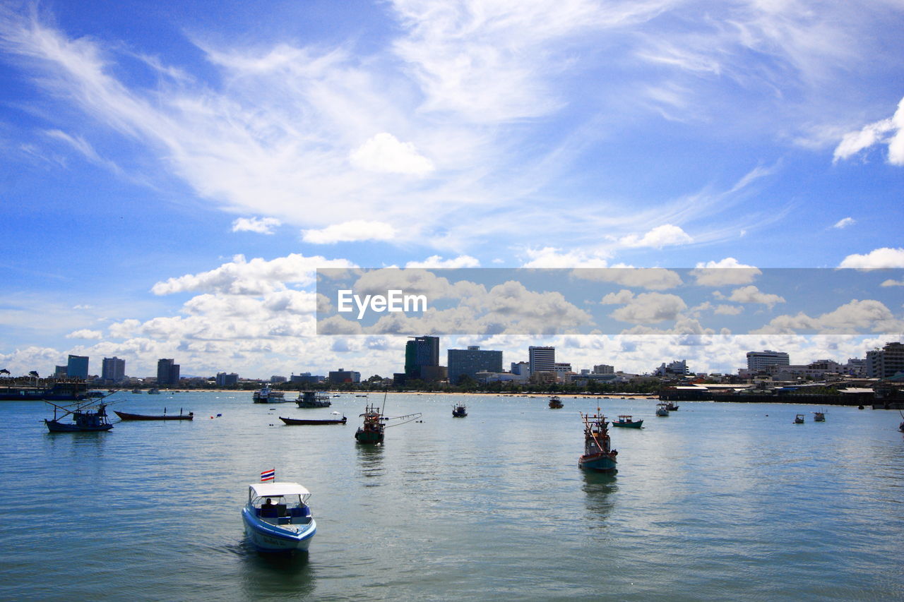 BOATS IN RIVER WITH BUILDINGS IN BACKGROUND