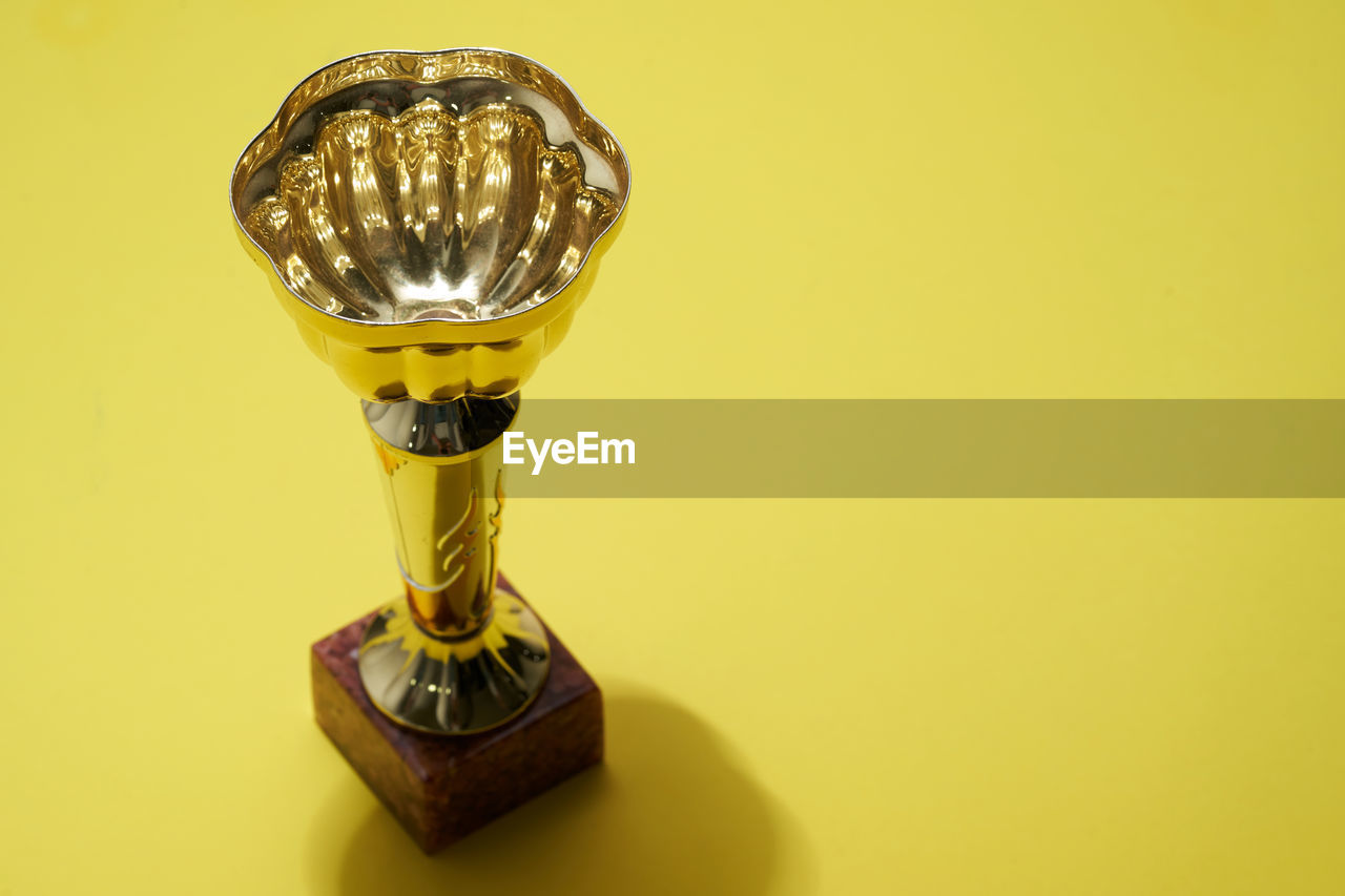 Close up of trophy on yellow background