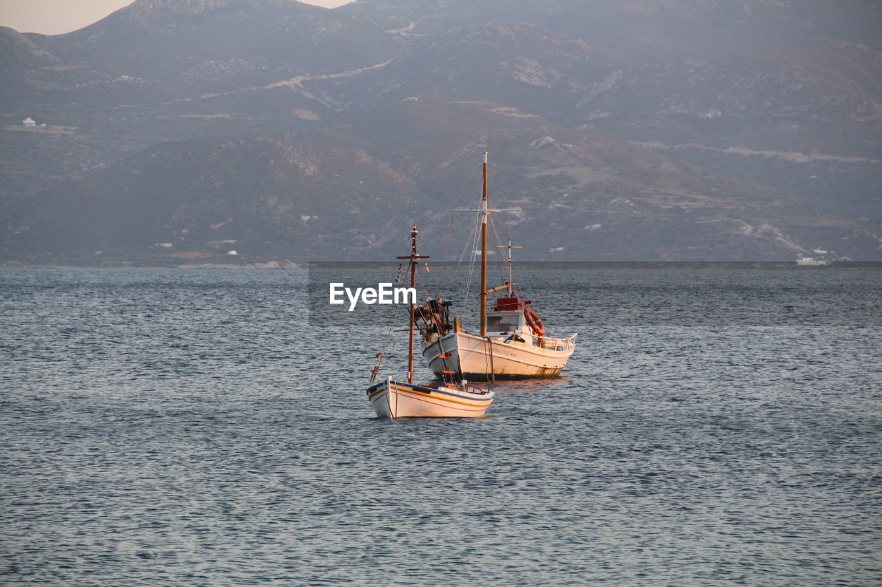 SAILBOAT SAILING IN SEA AGAINST SKY