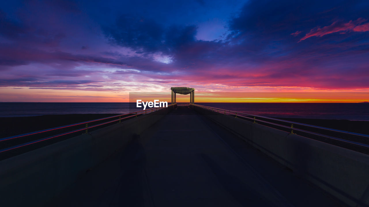 VIEW OF ROAD PASSING THROUGH LANDSCAPE AT NIGHT
