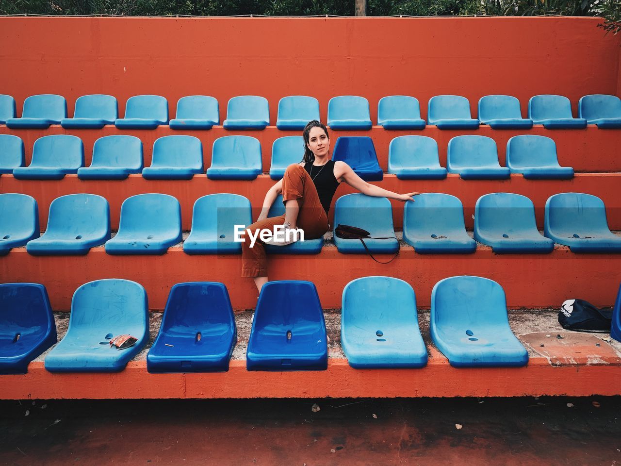 Full length of woman sitting on bleacher