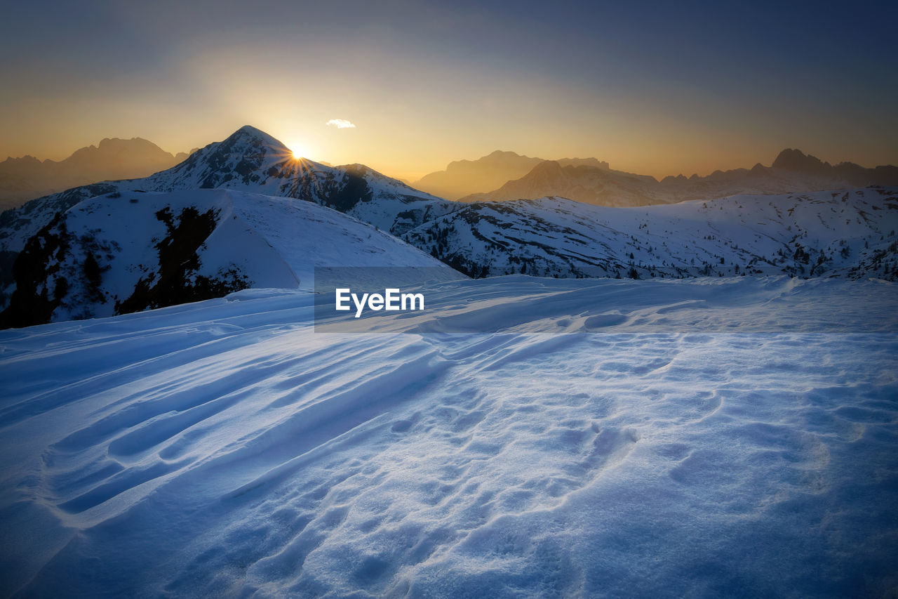 Scenic view of snowcapped mountains against sky during sunset