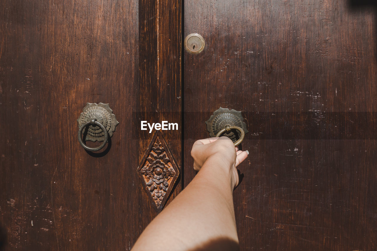 CLOSE-UP OF HUMAN HAND HOLDING DOOR