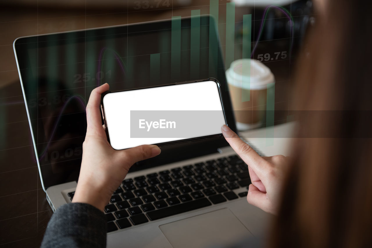 cropped hands of woman using laptop