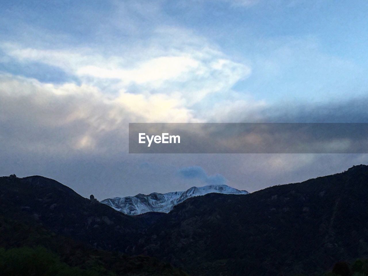 SCENIC VIEW OF MOUNTAINS AGAINST CLOUDY SKY