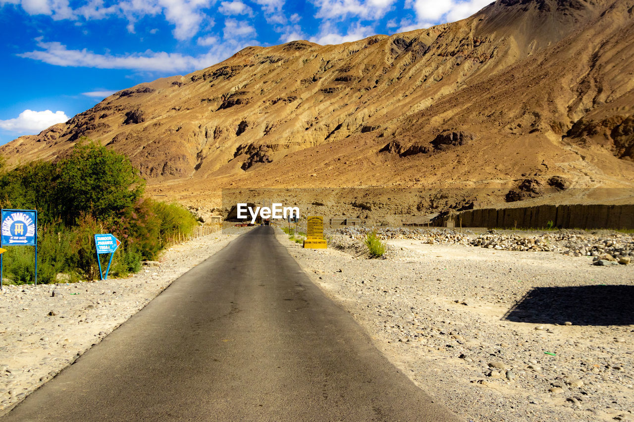 ROAD LEADING TOWARDS MOUNTAIN AGAINST SKY