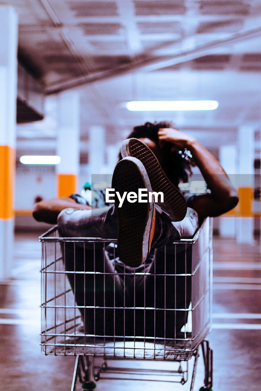 Man sitting in shopping cart