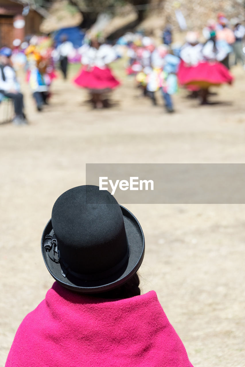 Rear view of woman wearing hat standing on street