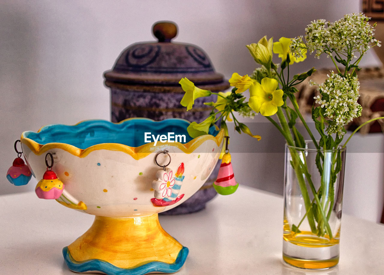 Close-up of colored objects and yellow flowers