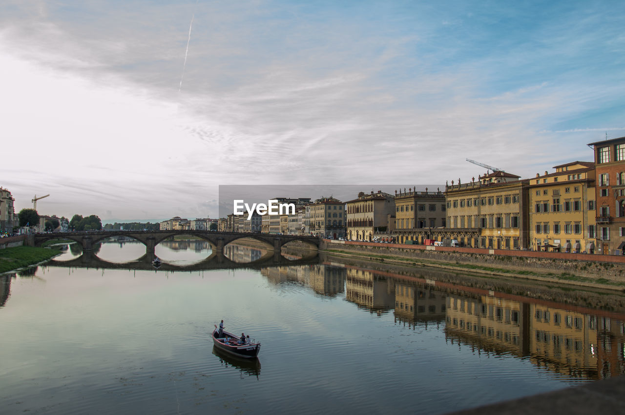 Bridge over river in city against sky