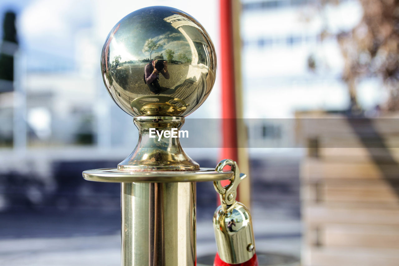 Reflection of man in golden railing