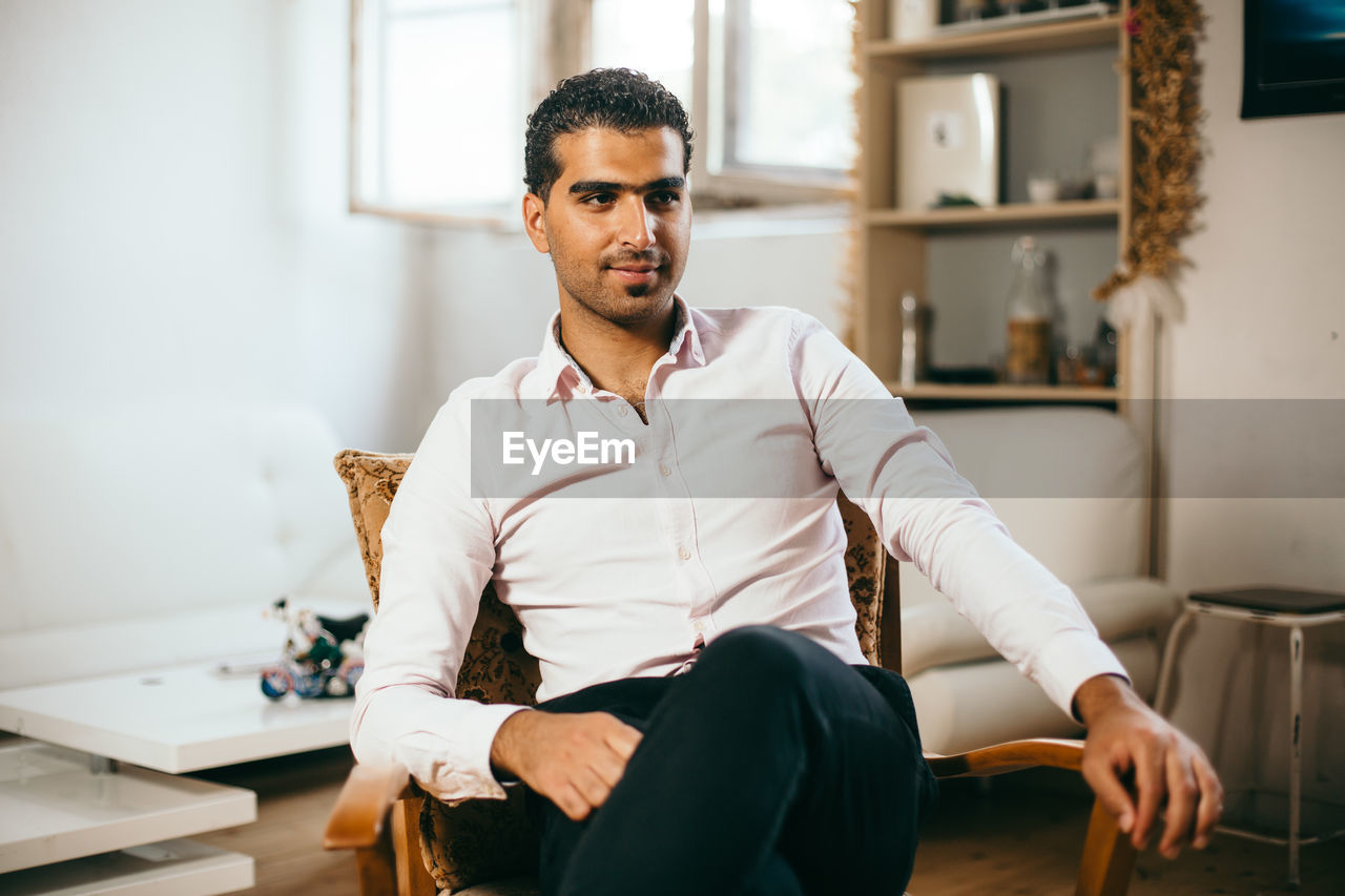 Confident young man sitting at home