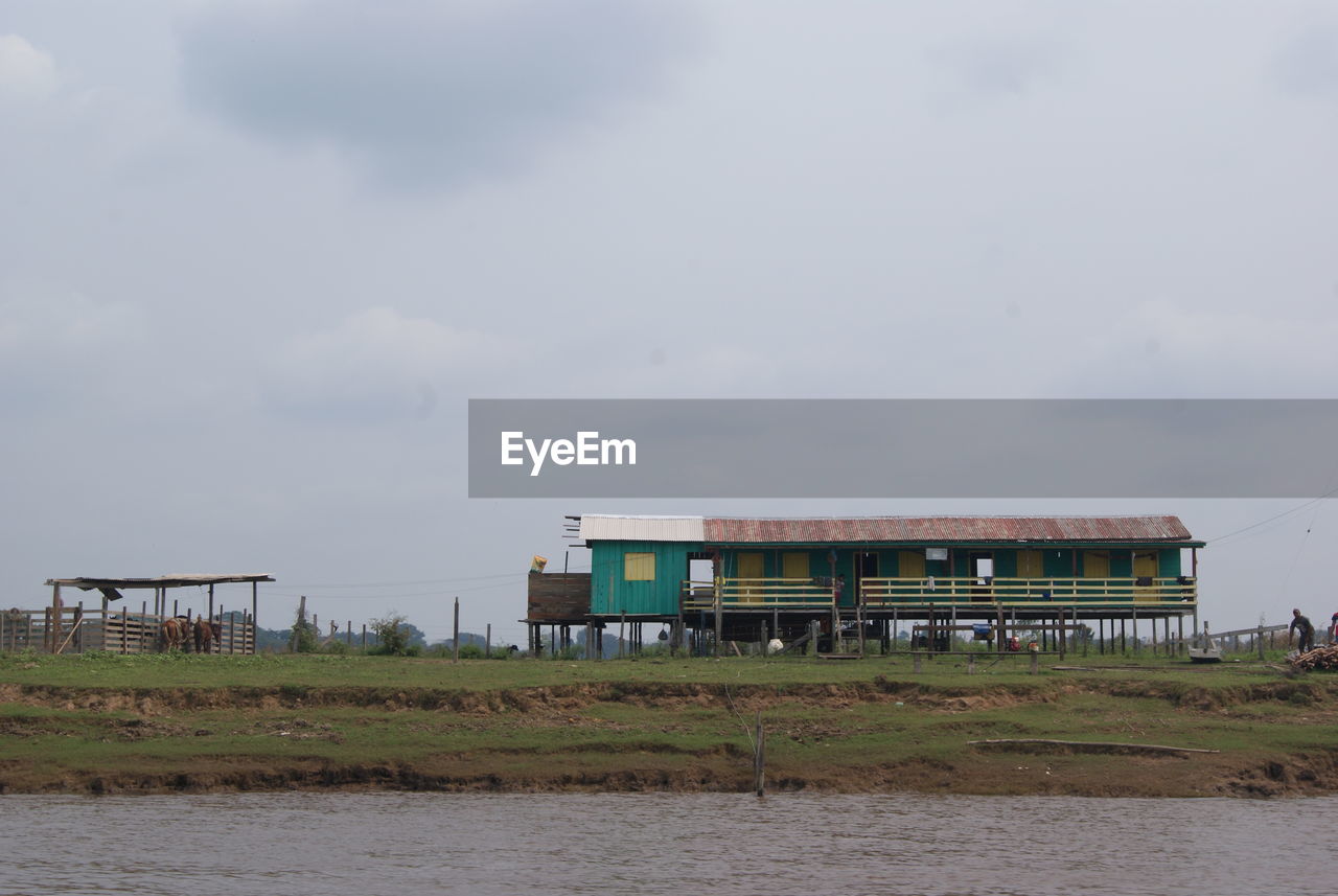 BUILT STRUCTURE BY LAKE AGAINST SKY