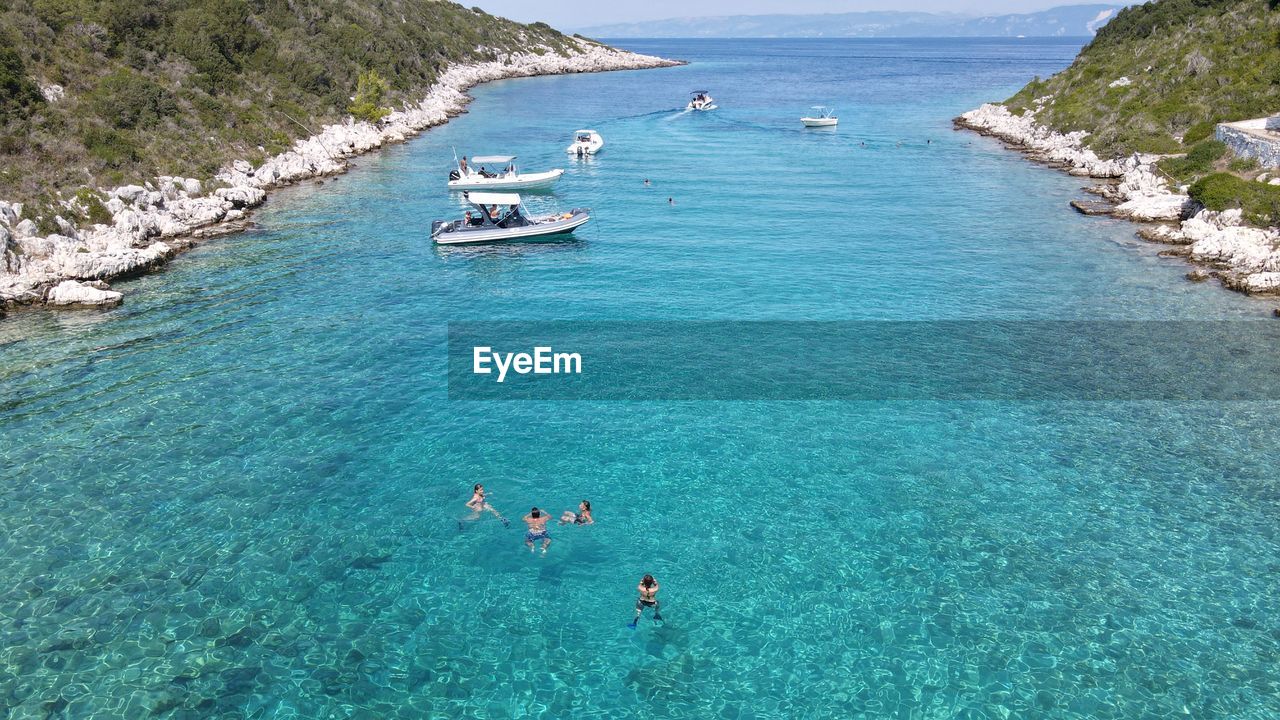 HIGH ANGLE VIEW OF PEOPLE IN SEA