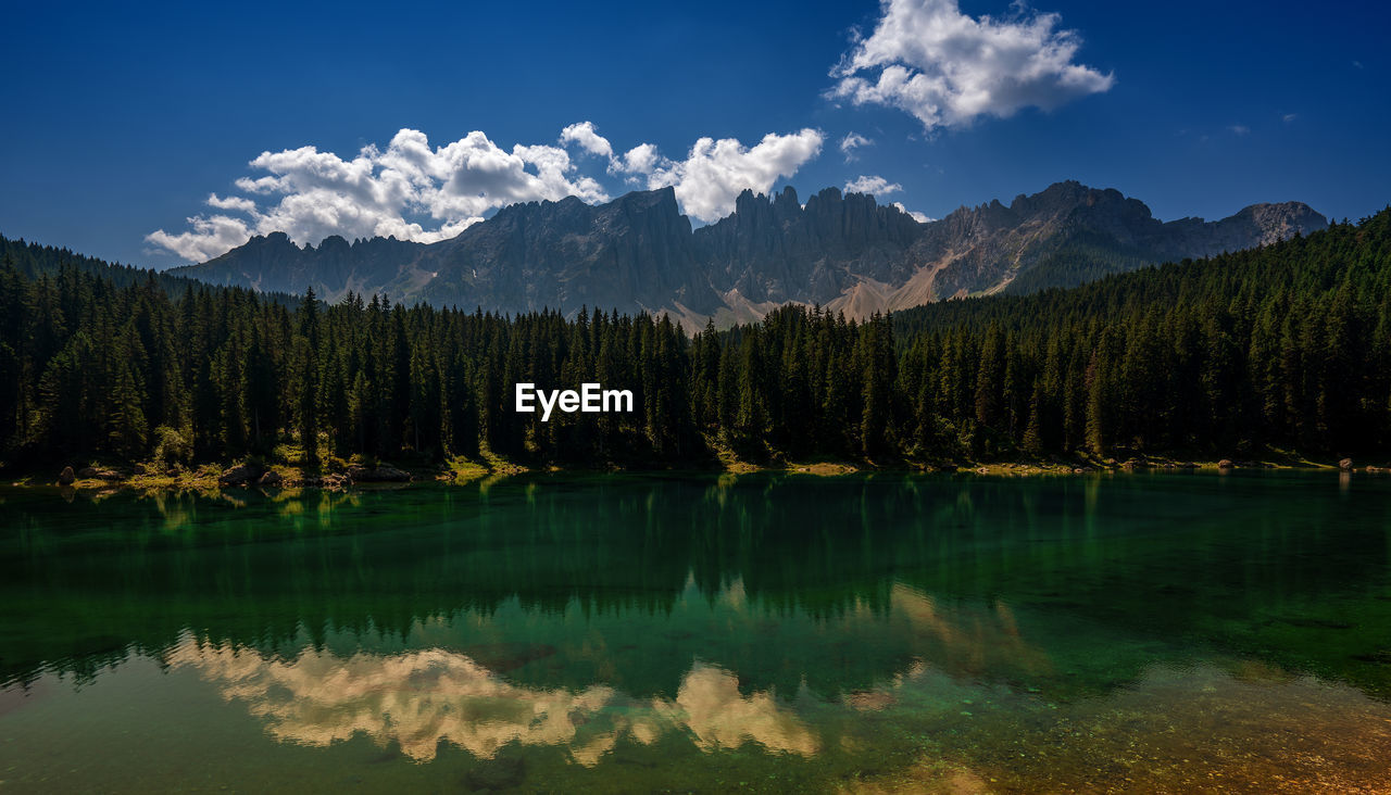 Reflection of trees and mountains in lake against sky