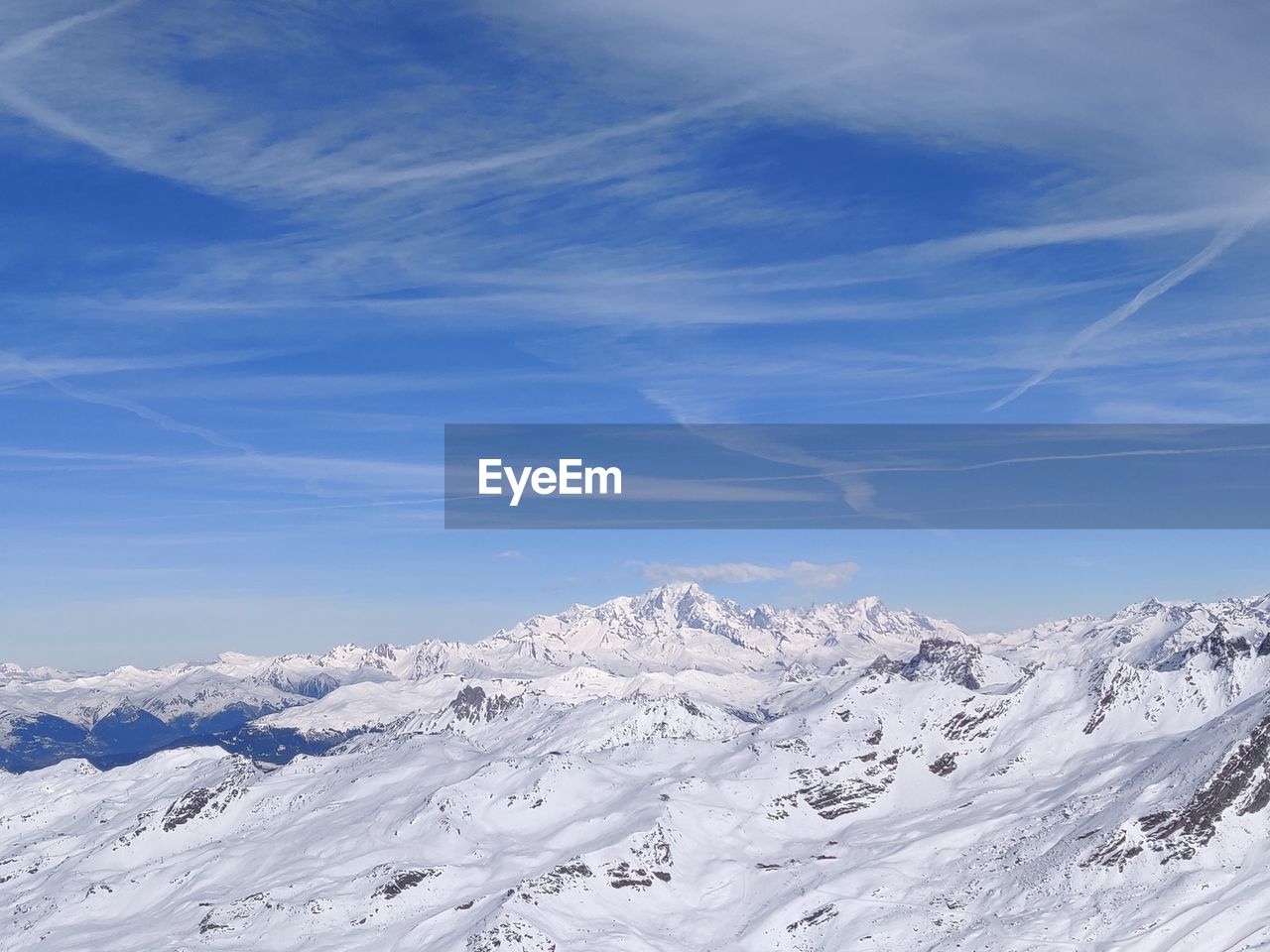 SNOW COVERED MOUNTAINS AGAINST BLUE SKY