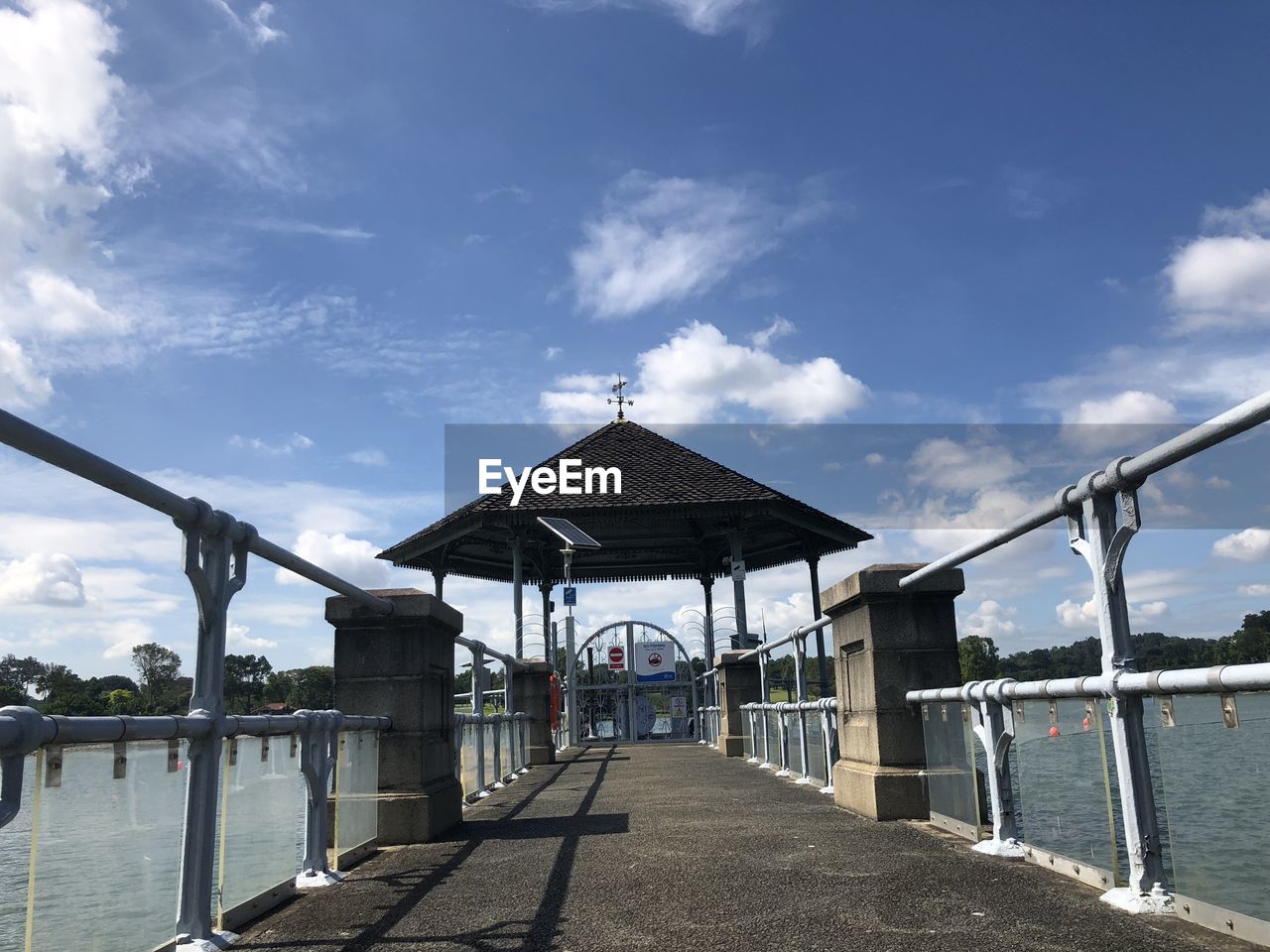 sky, architecture, built structure, cloud, water, nature, walkway, day, bridge, building exterior, the way forward, no people, outdoors, sea, transportation, travel destinations, railing, sunlight, building, footpath, pier, beach, city, tranquility, blue, travel, beauty in nature