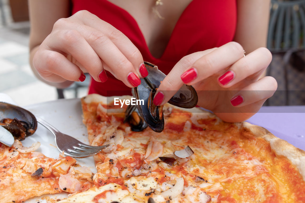 MIDSECTION OF WOMAN HOLDING PIZZA