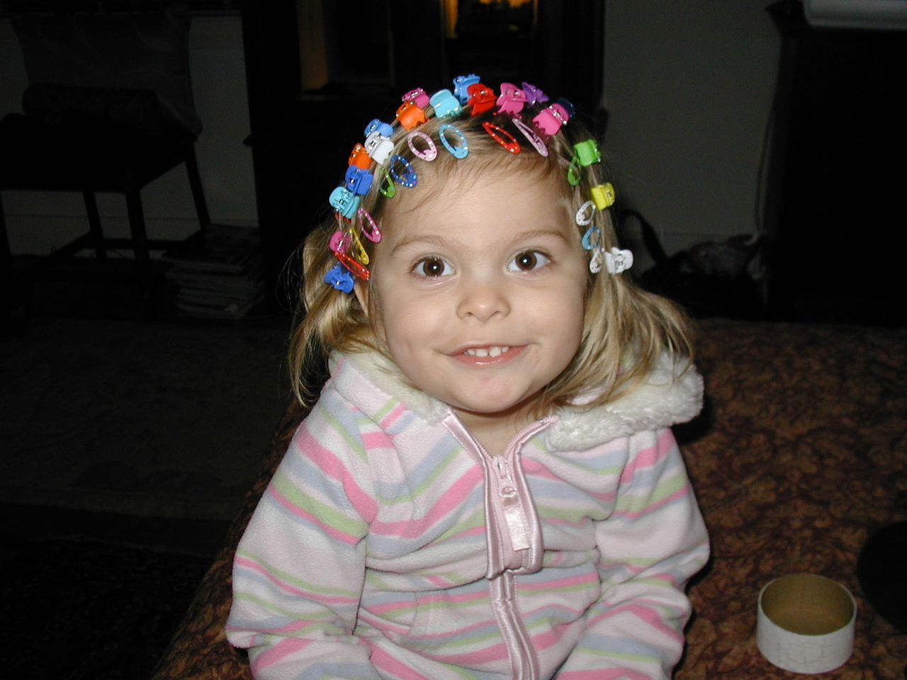 Cute girl wearing multi colored hair clips at home