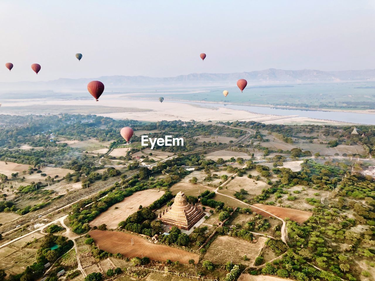 Hot air balloons flying over landscape