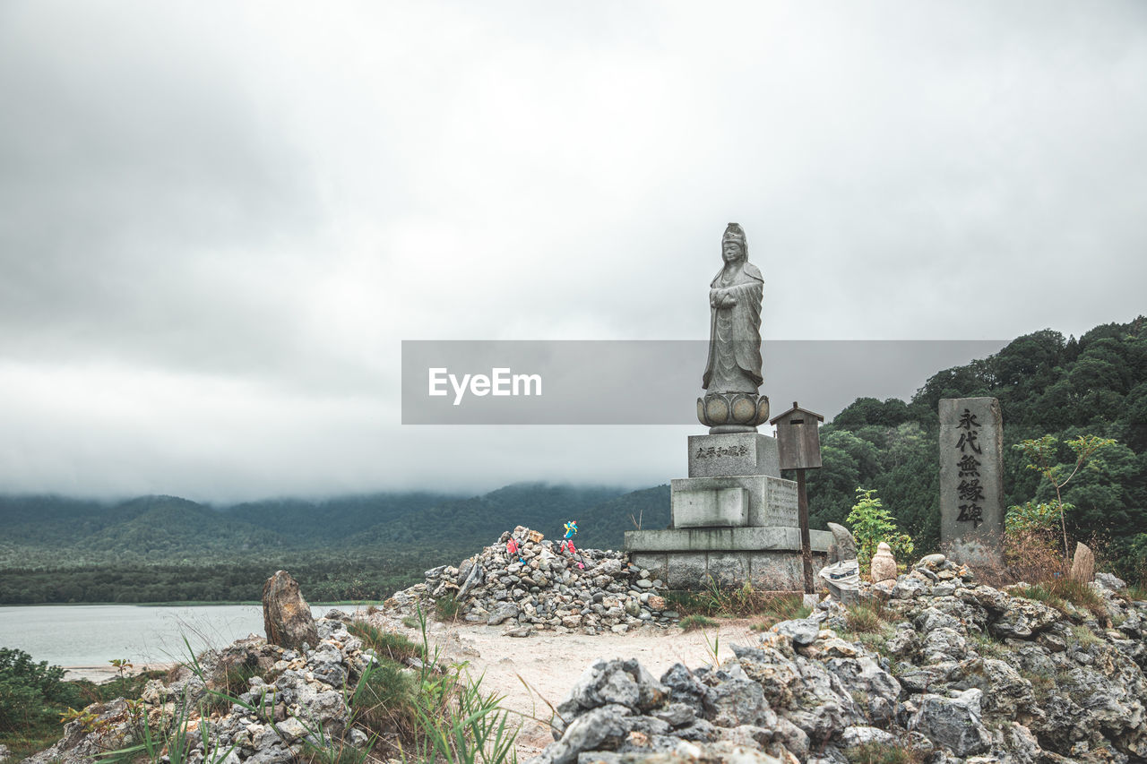 low angle view of statue against cloudy sky