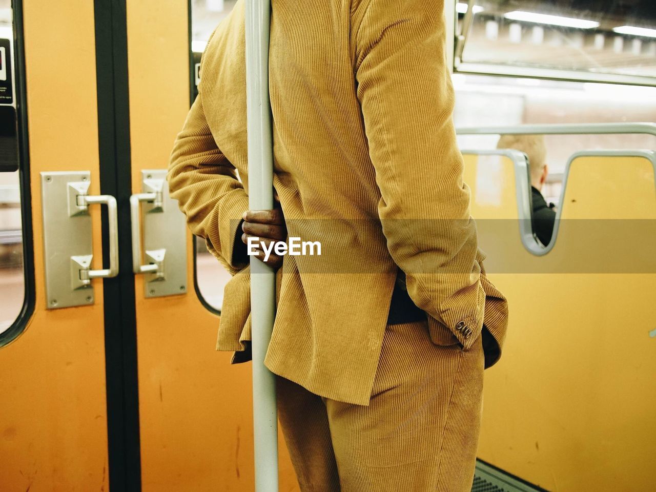 REAR VIEW OF MAN STANDING BY TRAIN