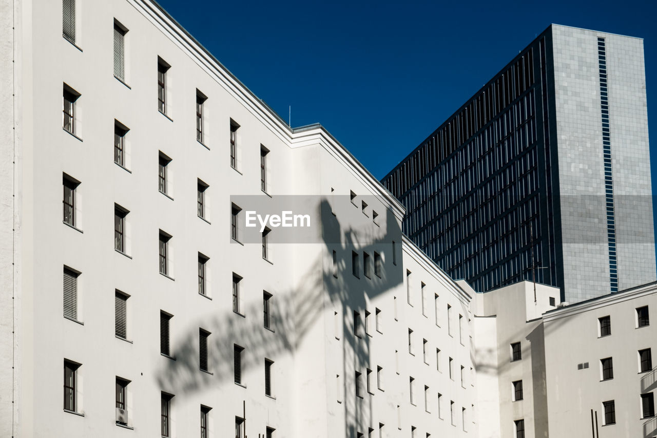 Shadow of crane on building during sunny day