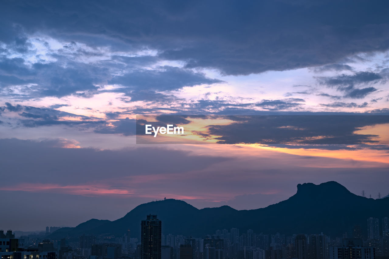 SILHOUETTE BUILDINGS IN CITY AGAINST SKY DURING SUNSET