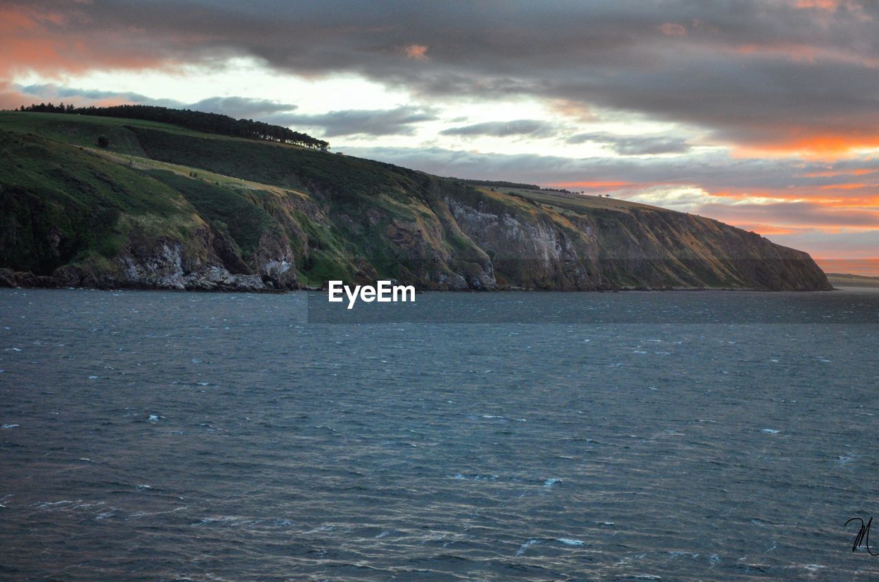 SCENIC VIEW OF SEA AGAINST SKY AT SUNSET