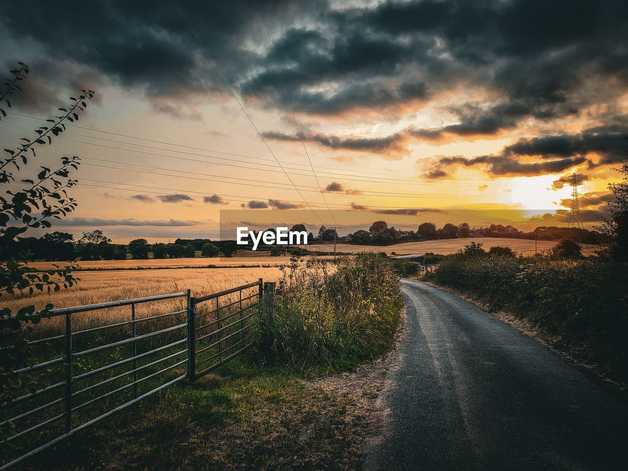 sky, cloud, morning, nature, sunrise, sunlight, beauty in nature, horizon, dusk, landscape, scenics - nature, road, environment, plant, water, dramatic sky, tranquility, land, transportation, no people, tranquil scene, sun, fence, outdoors, the way forward, rural scene, tree, sea, grass, idyllic, cloudscape, reflection, non-urban scene, footpath, afterglow, vanishing point