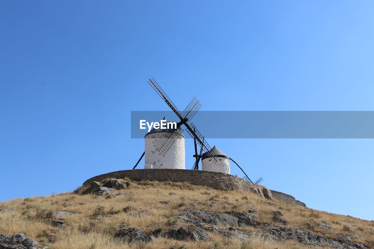 LOW ANGLE VIEW OF TRADITIONAL WINDMILL ON LANDSCAPE AGAINST CLEAR SKY