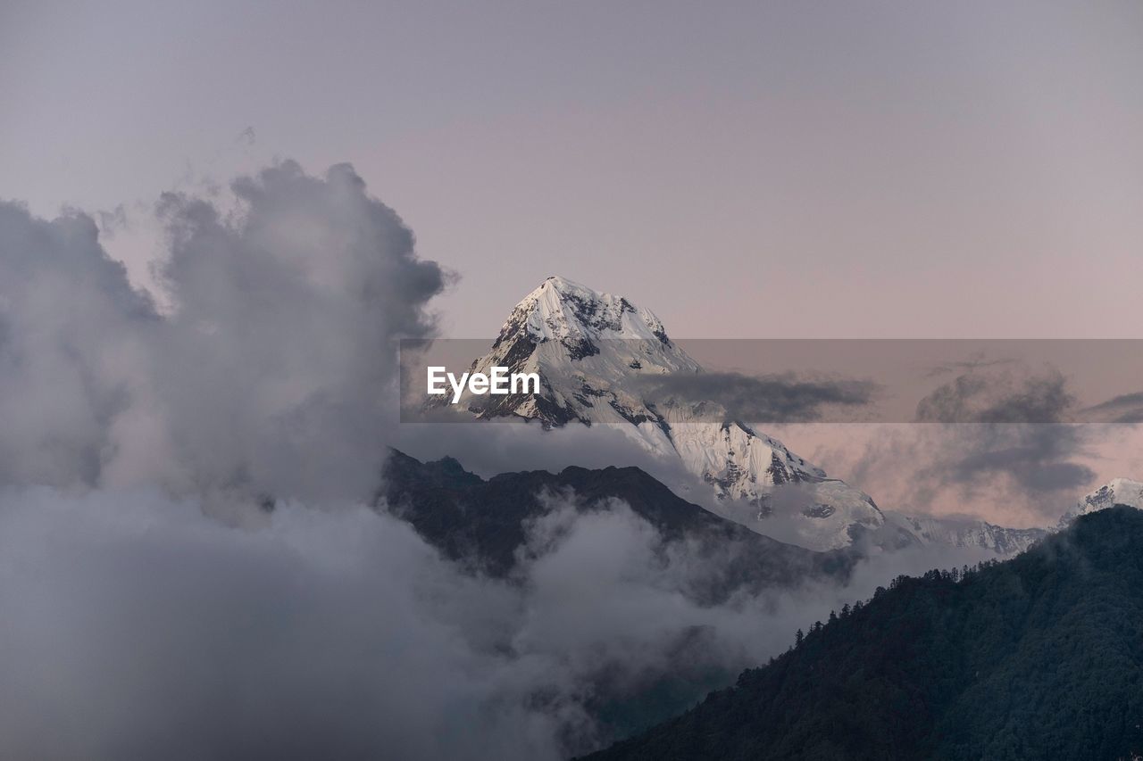 Low angle view of snow capped mountains against sky