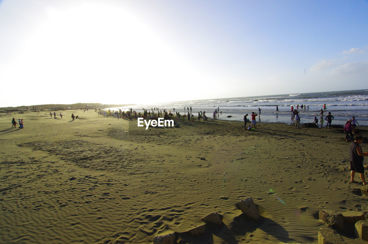 PEOPLE ON BEACH AGAINST SKY