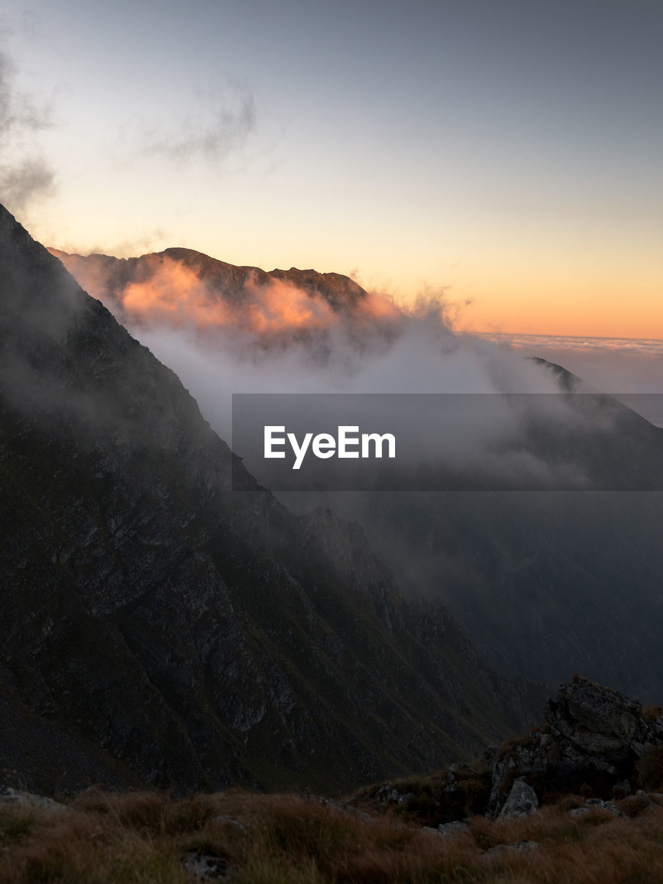 Scenic view of foggy mountains against sky during sunrise. fagaras mountains,romania.