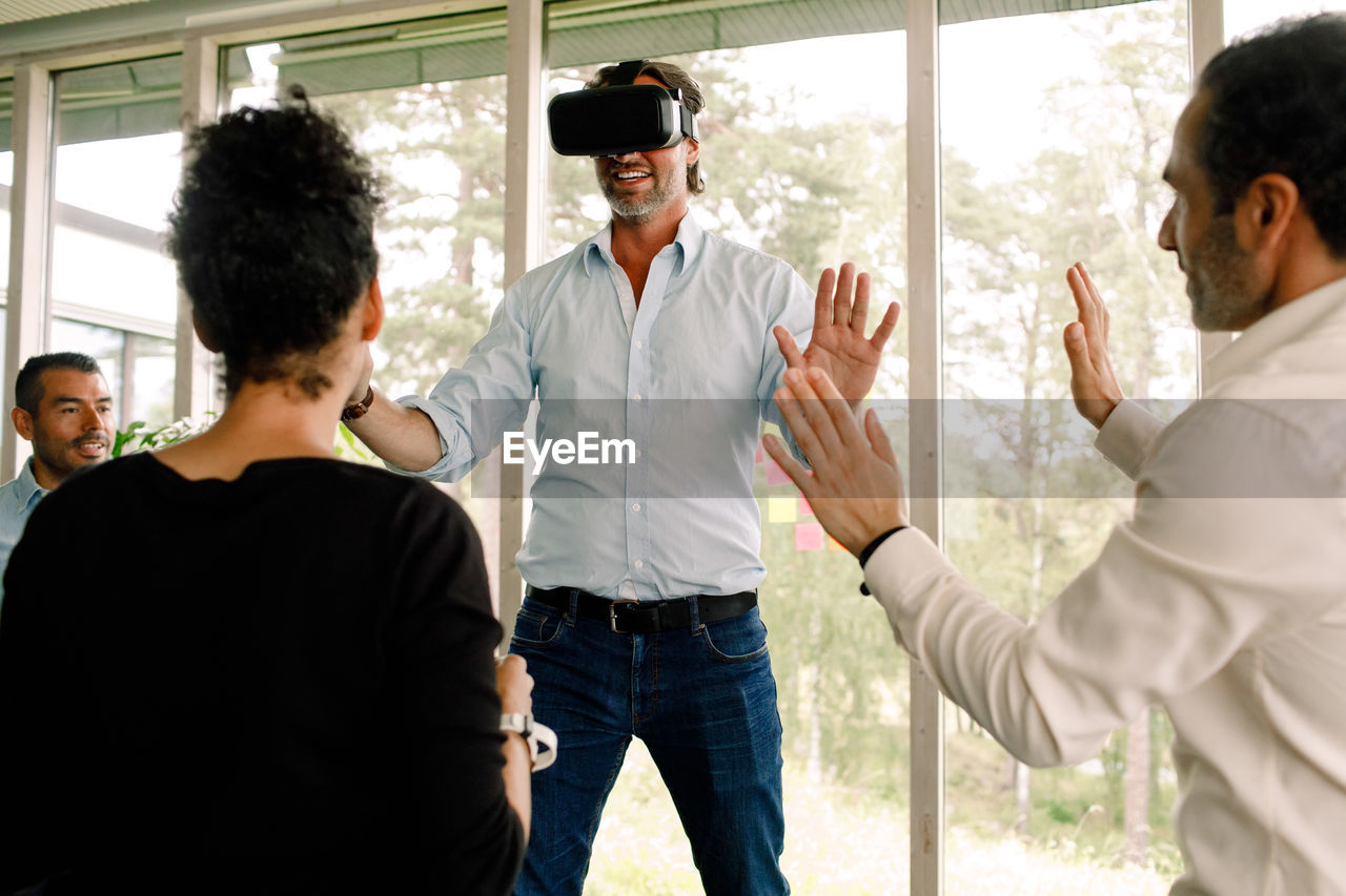 Businessman gesturing while wearing virtual reality simulator at convention center