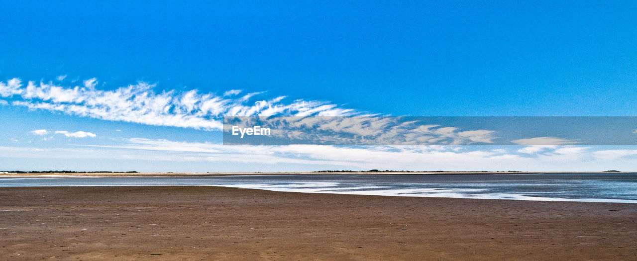 Scenic view of beach against blue sky