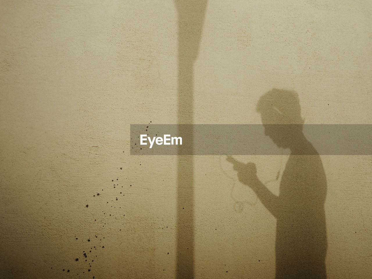 SHADOW OF PERSON ON WALL WITH TEXT