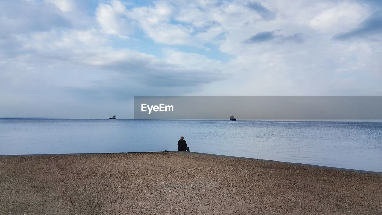 PEOPLE ON BEACH AGAINST SKY