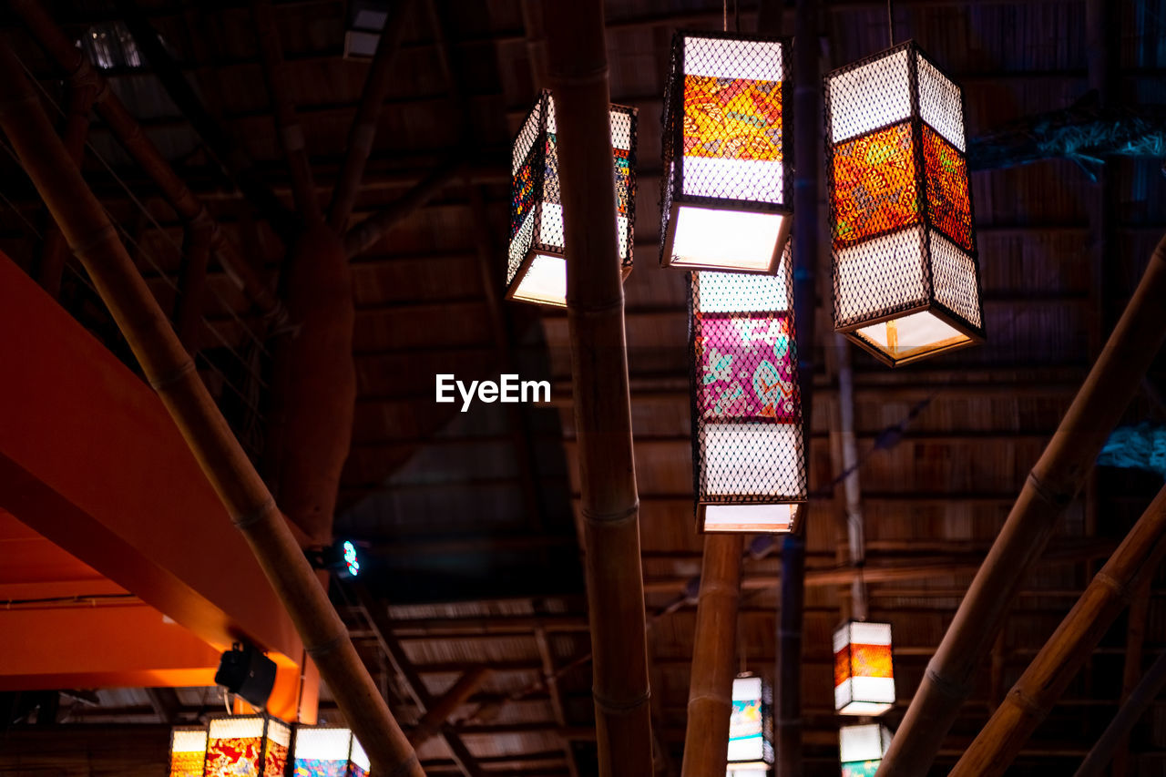 LOW ANGLE VIEW OF ILLUMINATED LANTERNS HANGING ON BUILDING