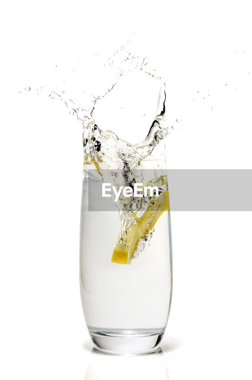 CLOSE-UP OF GLASS OF WATER AGAINST WHITE BACKGROUND