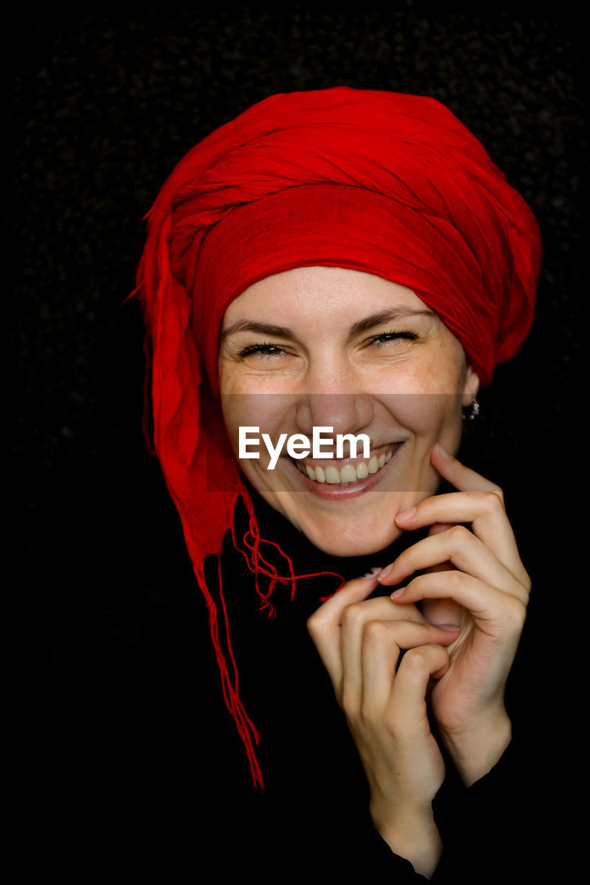 Woman wearing headscarf against black background