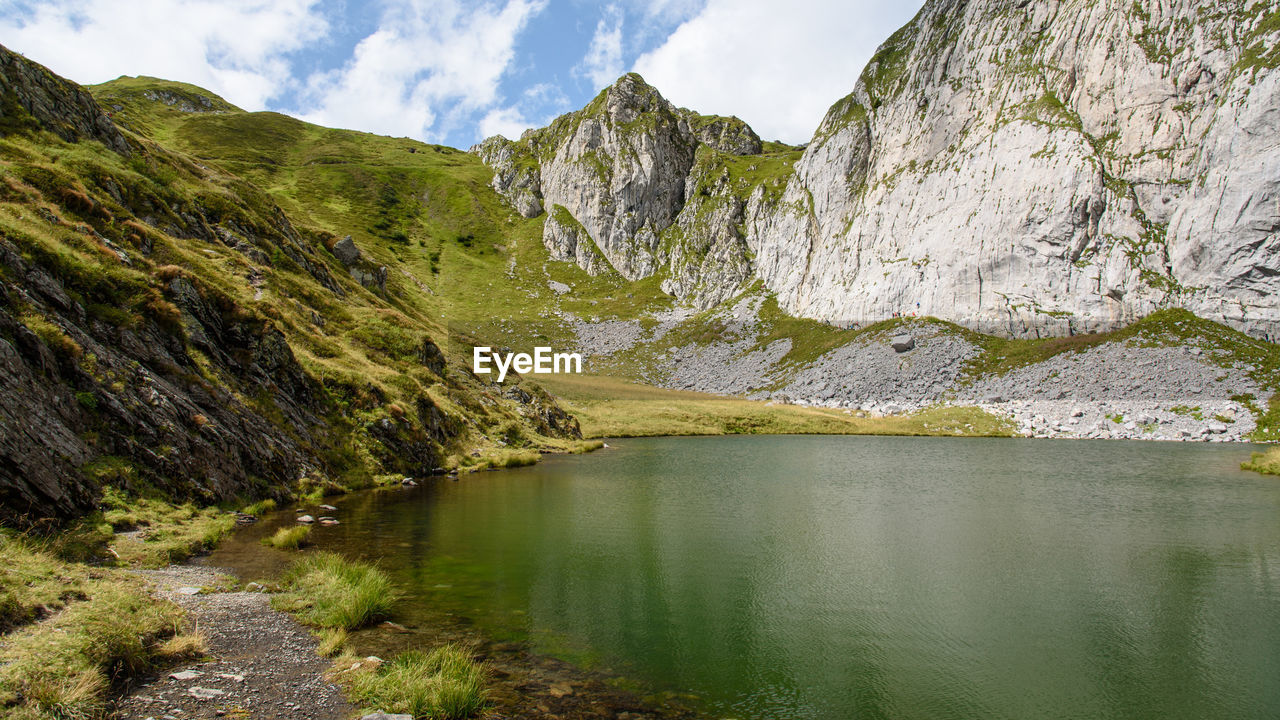 SCENIC VIEW OF LAKE AMIDST MOUNTAINS AGAINST SKY