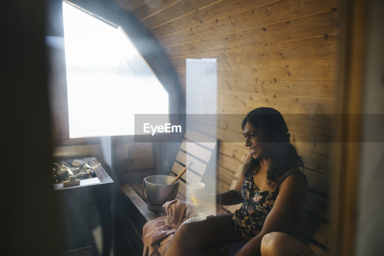 Smiling woman relaxing inn sauna