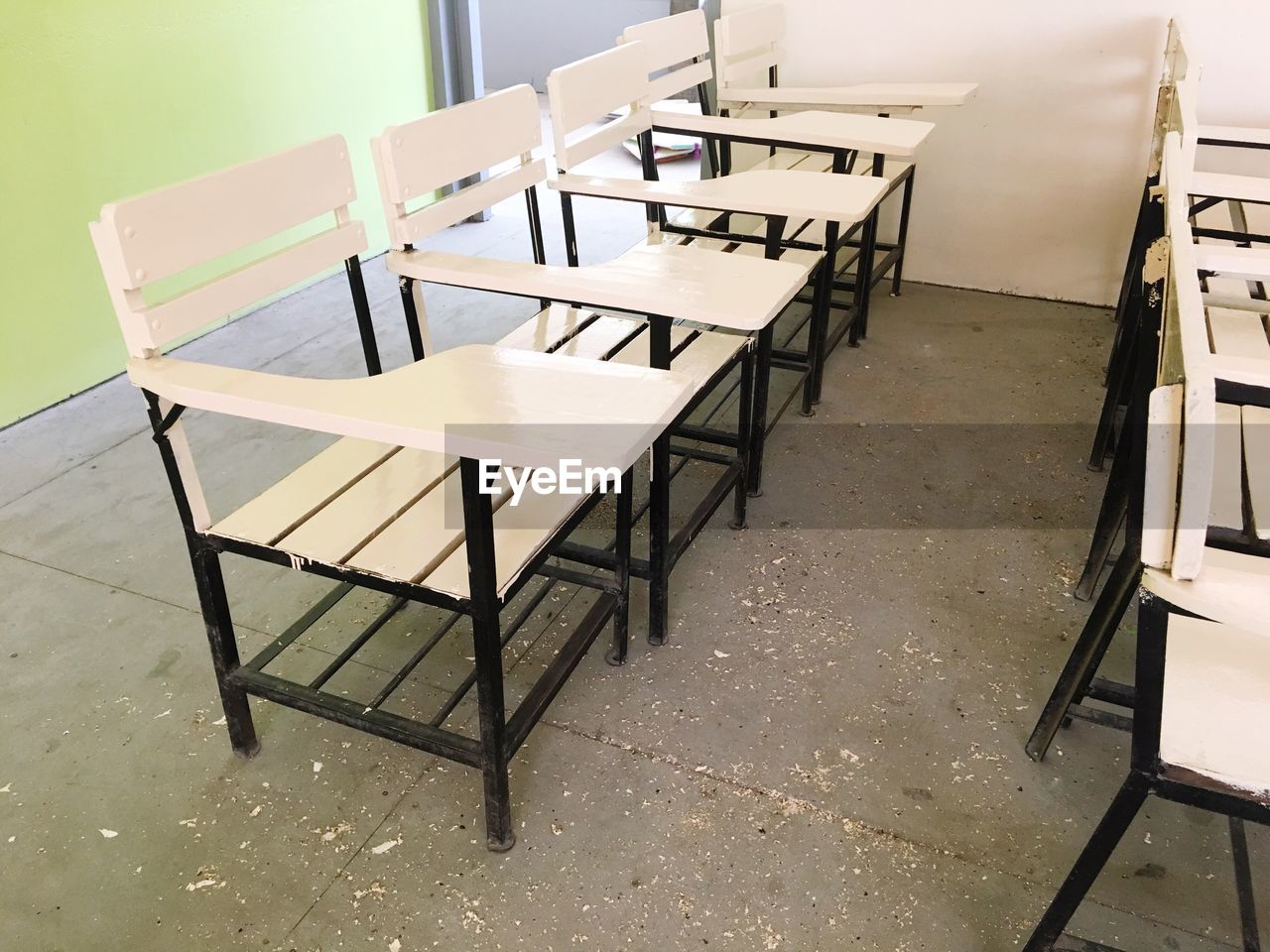 EMPTY CHAIRS AND TABLE IN ABANDONED BUILDING