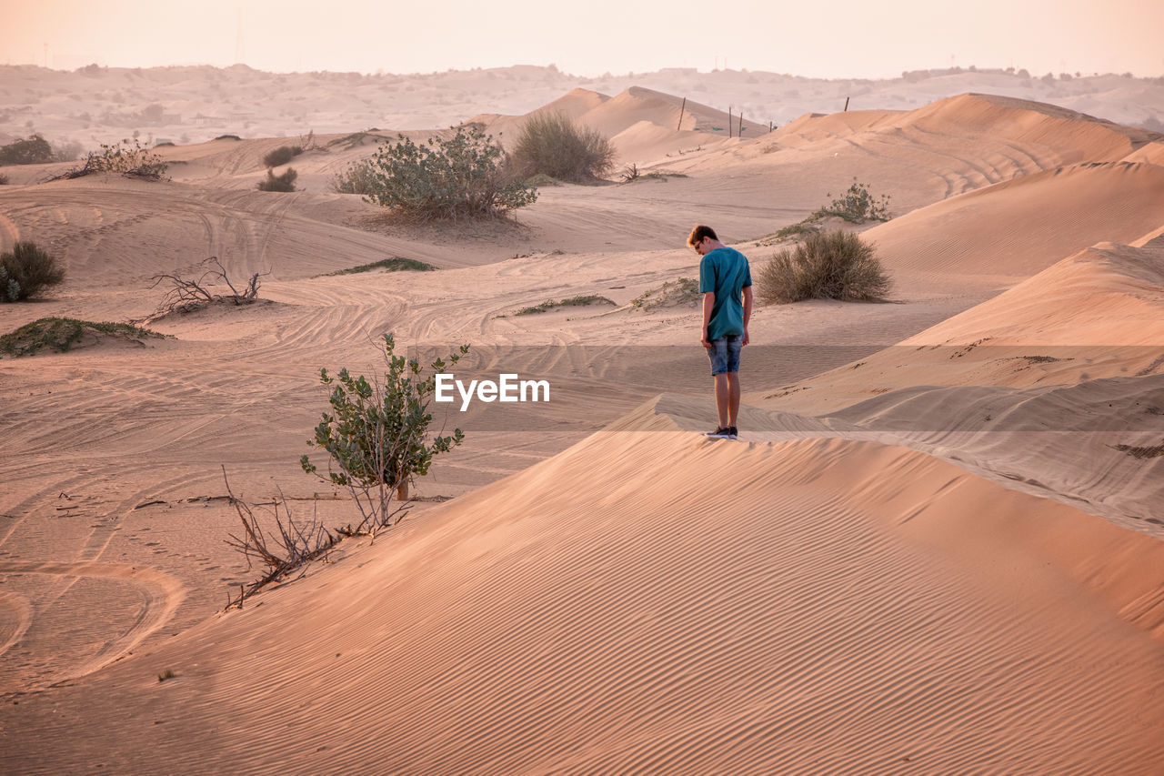 Rear view of man on sand dune in desert