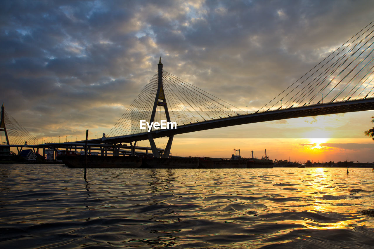 SUSPENSION BRIDGE OVER SEA DURING SUNSET