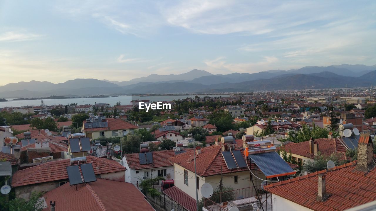 HIGH ANGLE VIEW OF TOWNSCAPE BY MOUNTAINS AGAINST SKY